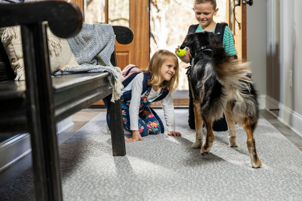 Kids playing with dog on carpet floors | Green's Floors & More